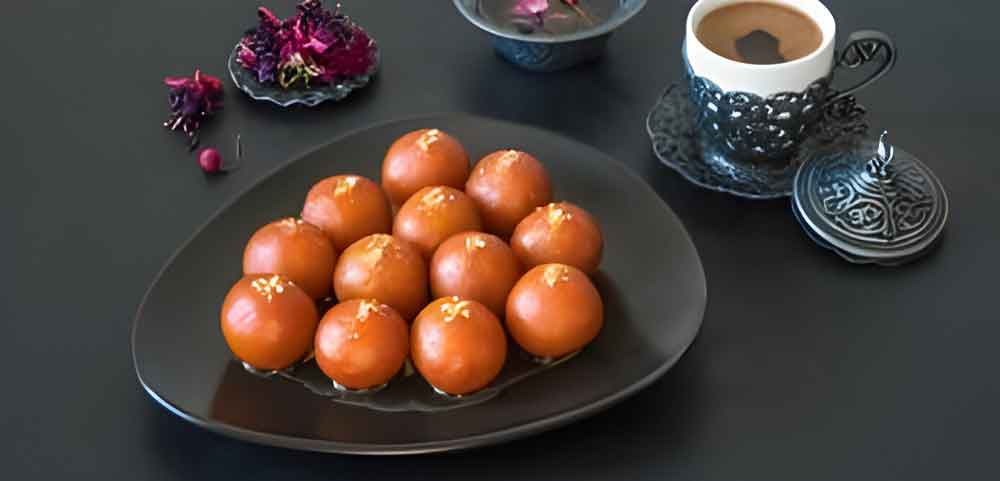 Gulab Jamun prepared with traditional ingredients, highlighting its delicate texture and glossy syrup coating