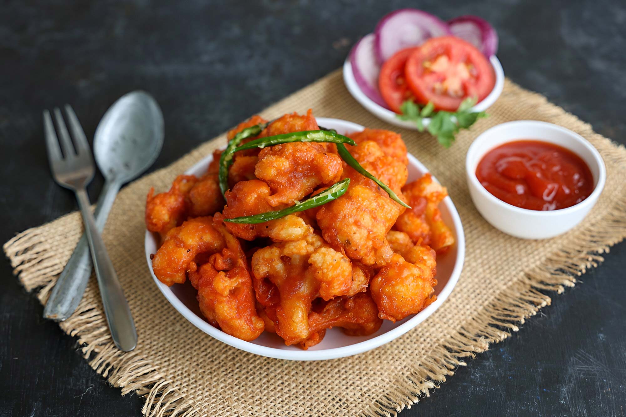 Gobi Manchurian showcasing golden cauliflower pieces coated in Indo-Chinese seasonings and aromatic ingredients