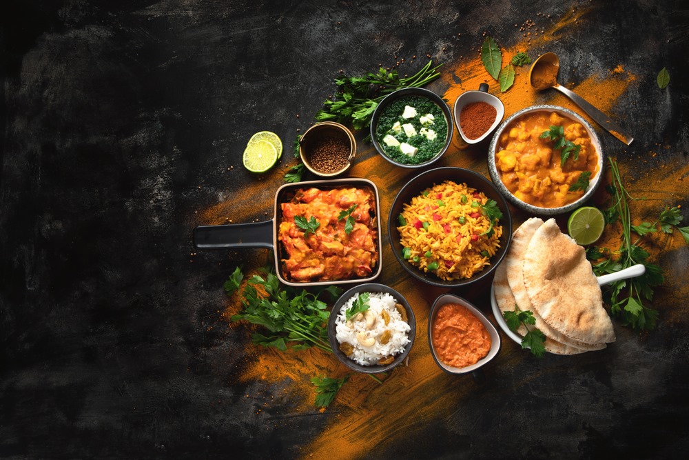 Indian Cuisine featuring a vibrant spread of curries, rice dishes, breads, and appetizers arranged for serving